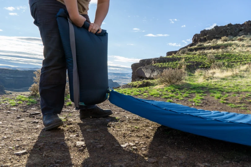 a camper uses the pump sack to inflate the mattress in eastern washington