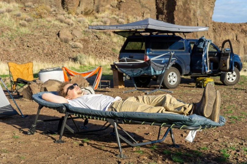the author laying on the comfort cot in camp in eastern washington