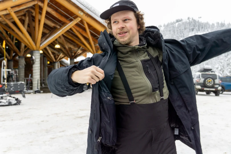 a tester throws on the l.l.bean main warden's parka in a ski area parking lot