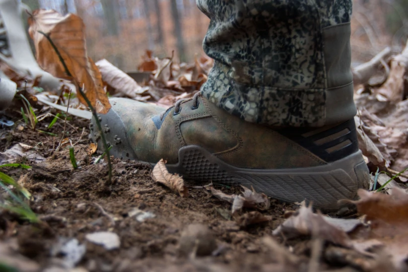 A hunting boot stepping in the dirt.