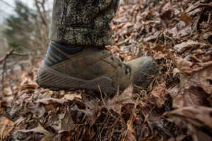 The Irish Setter VaprTrek boot flexing as a hunter walks uphill on leaf covered terrain.
