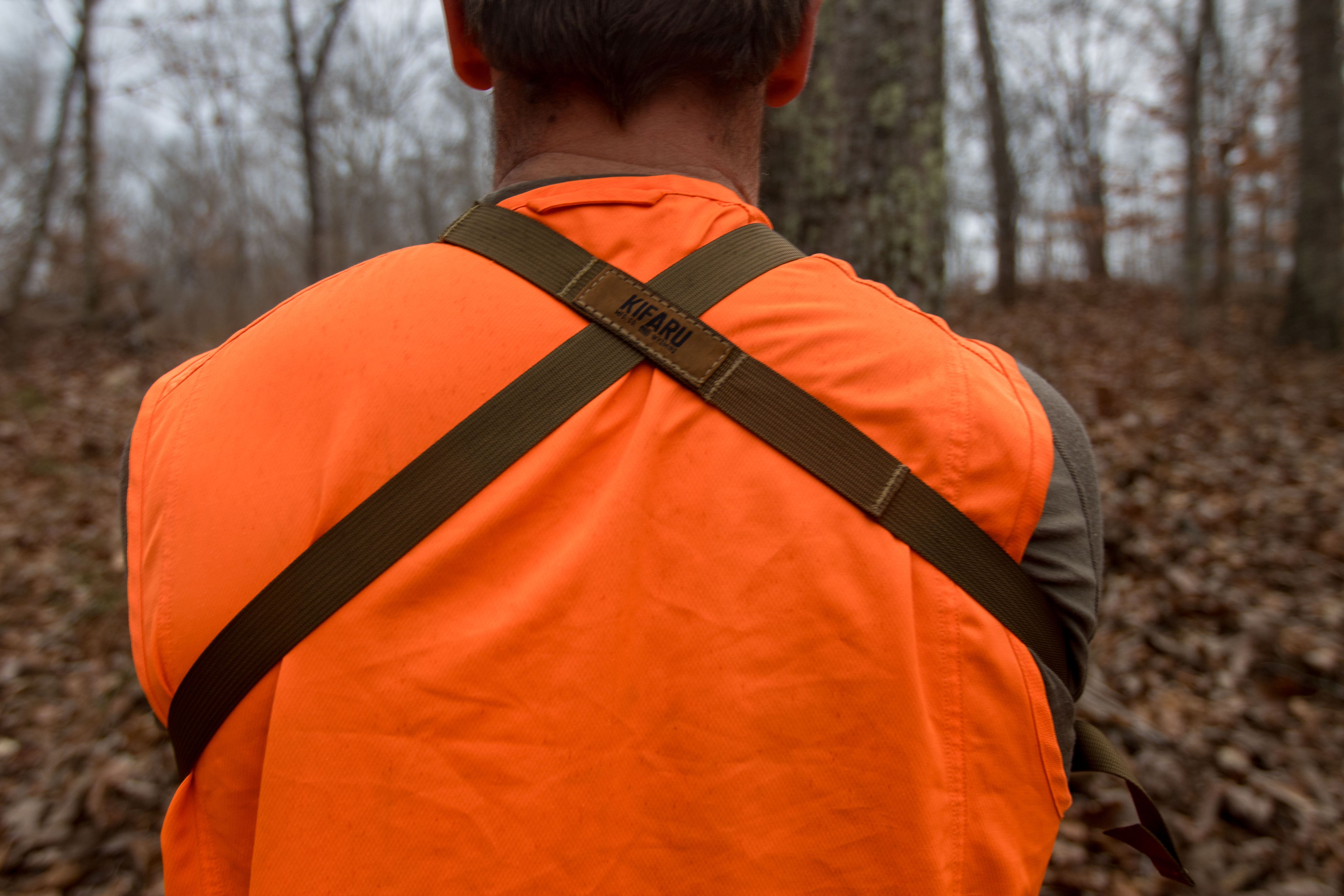 The straps of a harness on a hunters back.