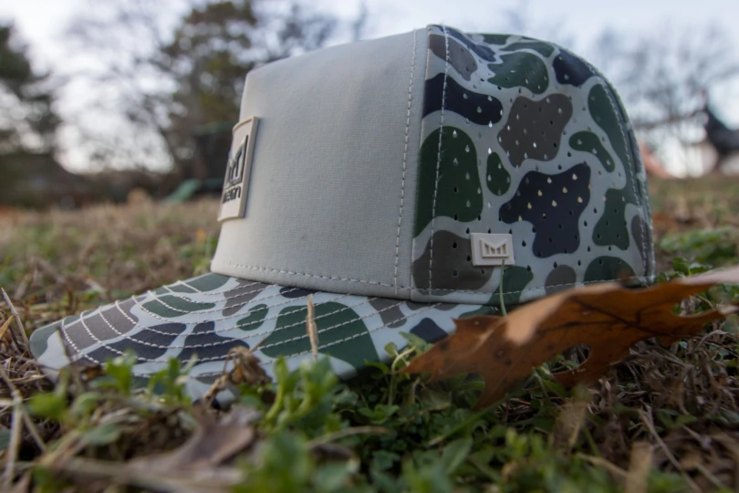 The side view of a baseball hat in grass.