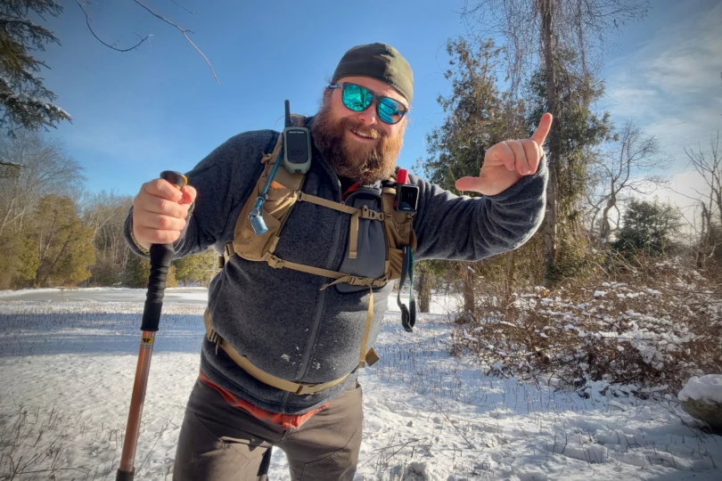 A hiker wearing the Mountainsmith Mayhem EVO 30L Backpack on a snowy trail