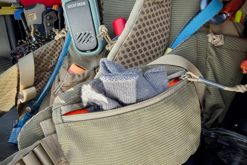 Close-up of the backpack shoulder straps with attached radio and hydration tube