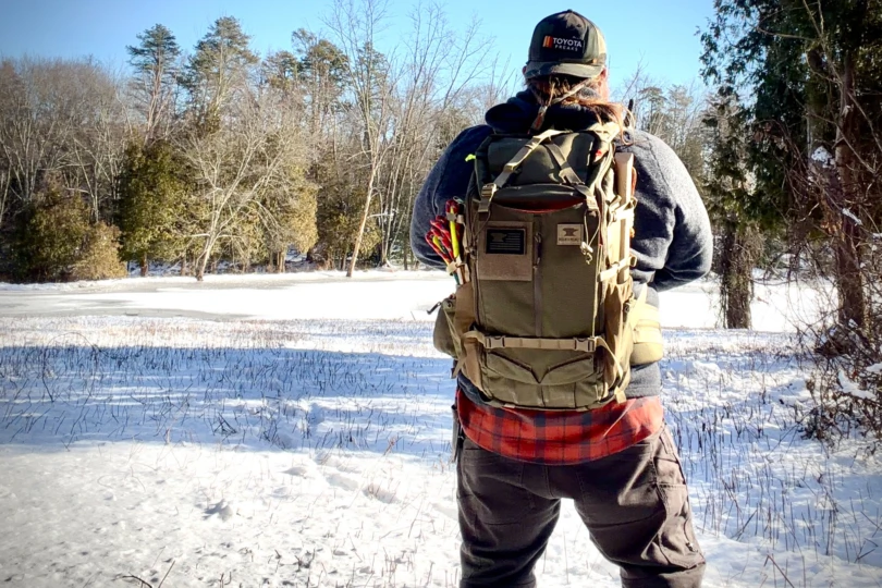 Rear view of a person wearing the Mountainsmith Mayhem backpack in a snowy field