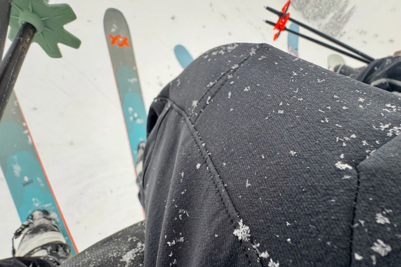 Snow resting on the surface of the Flex1 ski pants near the knee