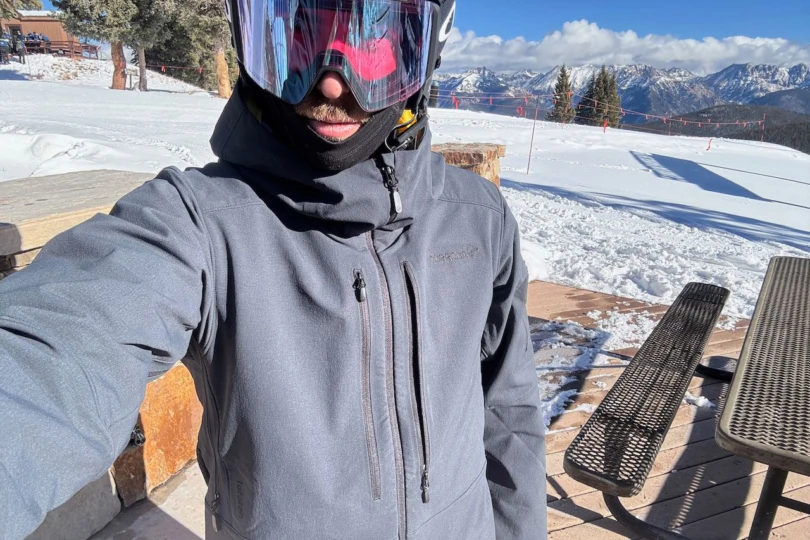 Front view of the Norrona Lofoten jacket worn with goggles at the ski resort