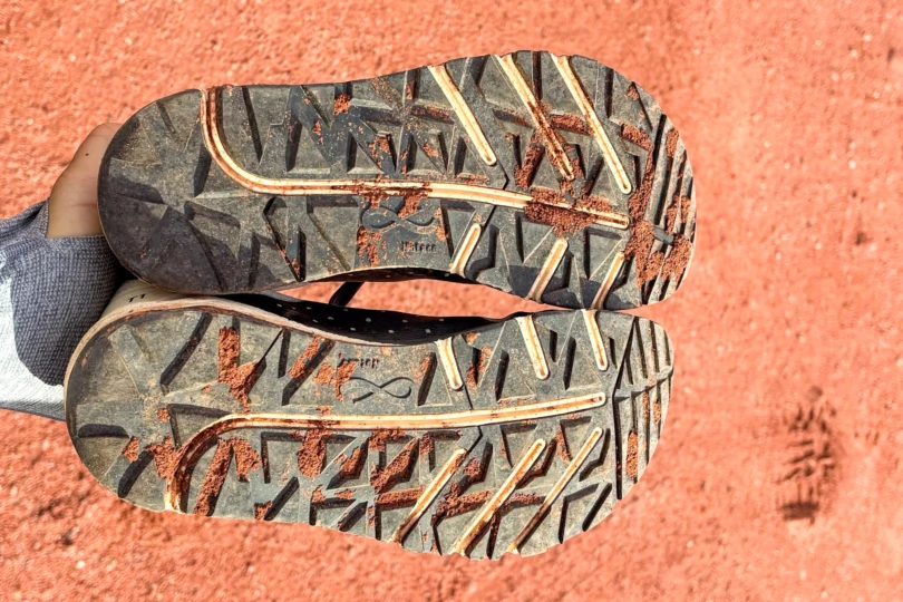 The Notace Yama T1 outsole covered in red trail dust