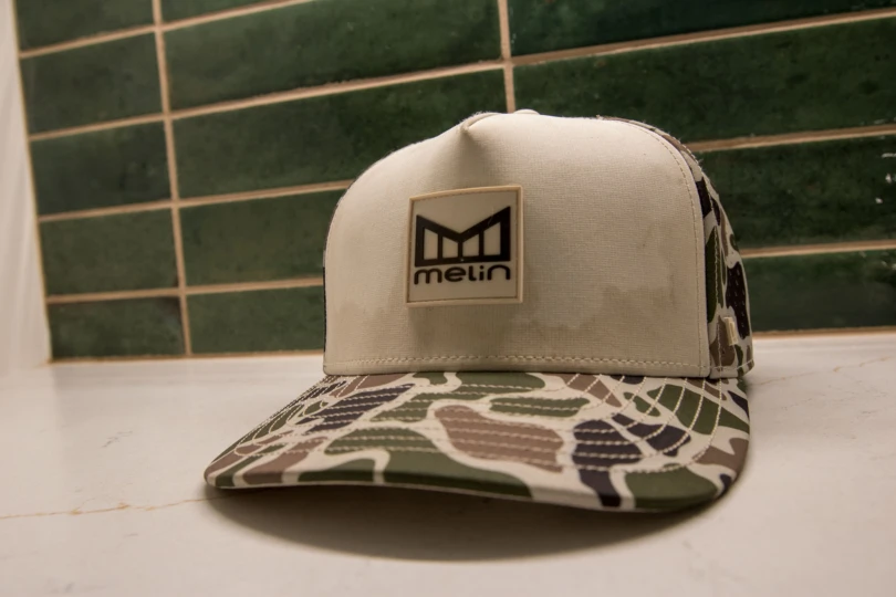 The Melin Odysea Stacked Hydro Hat with sweat stains on it sitting on a counter top.