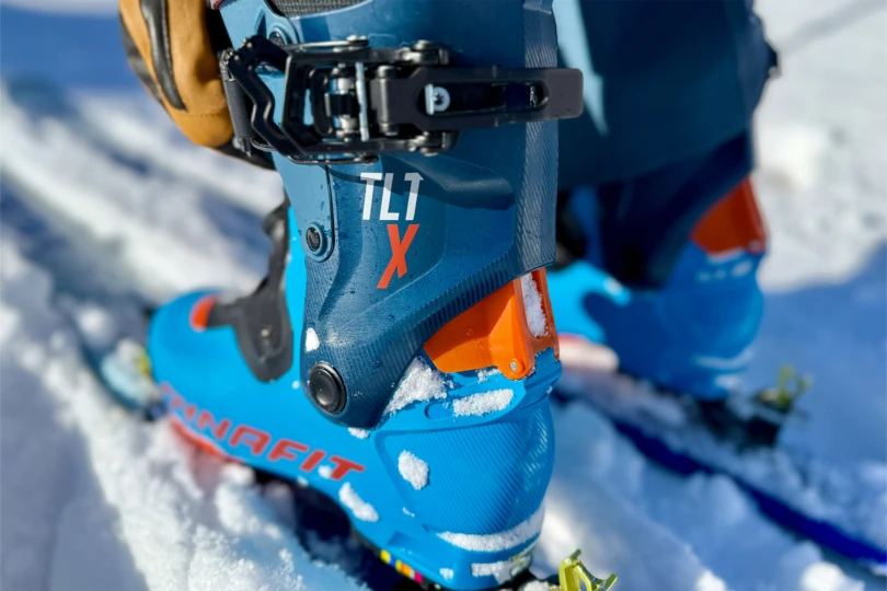 The heel of the lightweight boot shows snow on the cuff and hardware