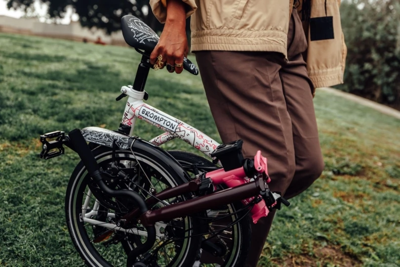 Close-up shot of person carrying folded up commuter bike