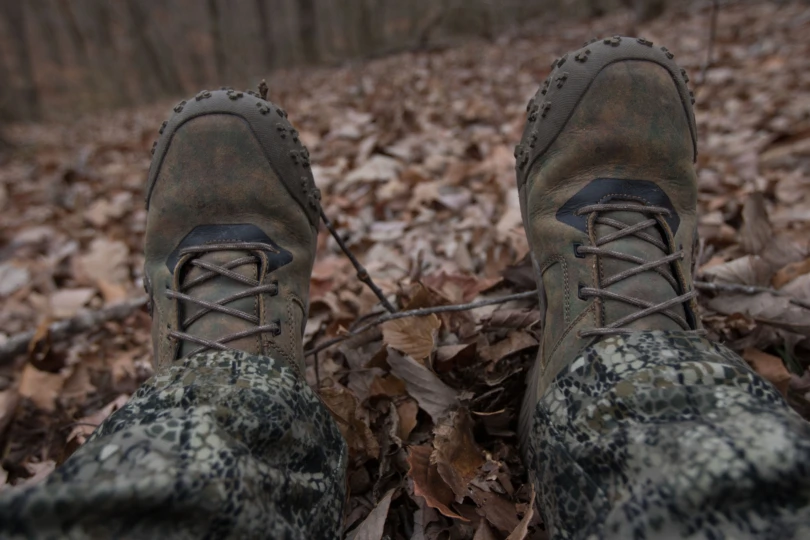 A hunters feet in the woods.