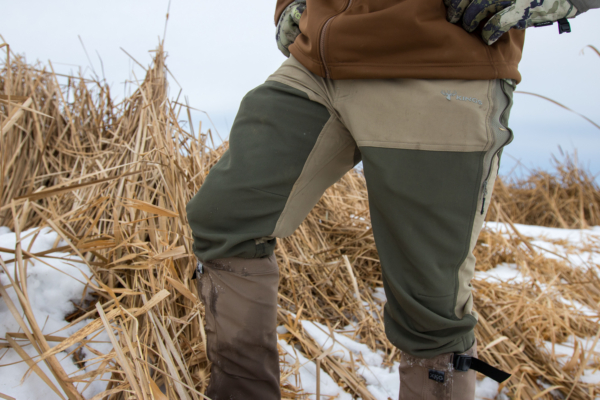 A close up shot of a hunter wearing the Kings Camo XKG Field Pant in front of a cattail slough.