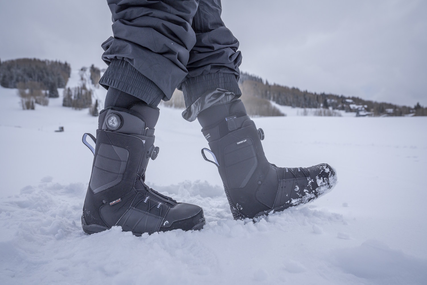 Rider wearing snowboard boots while standing in fresh snow.