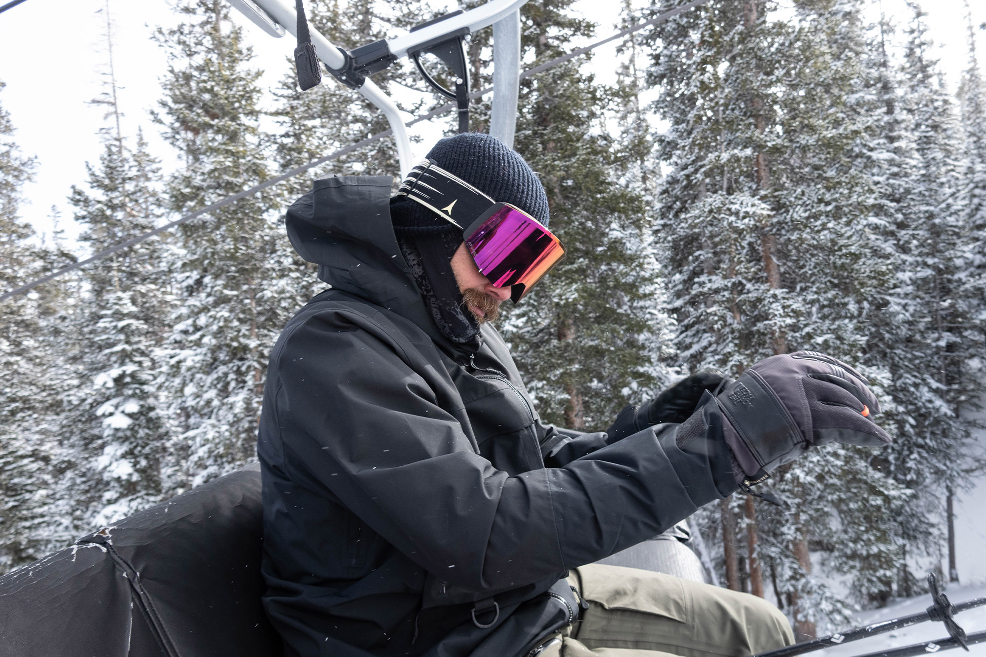 Adjusting gloves on the lift while the First Chair coat sheds snow