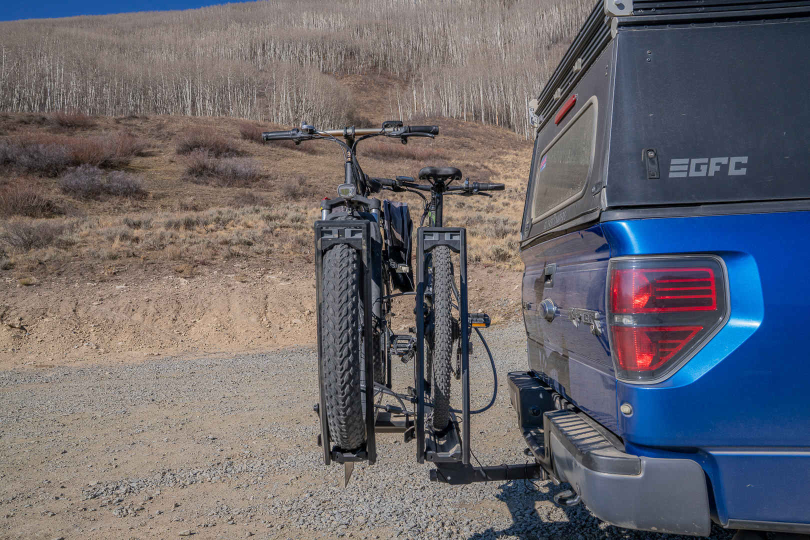 Two bikes sit upright in the rack with wide tires supported