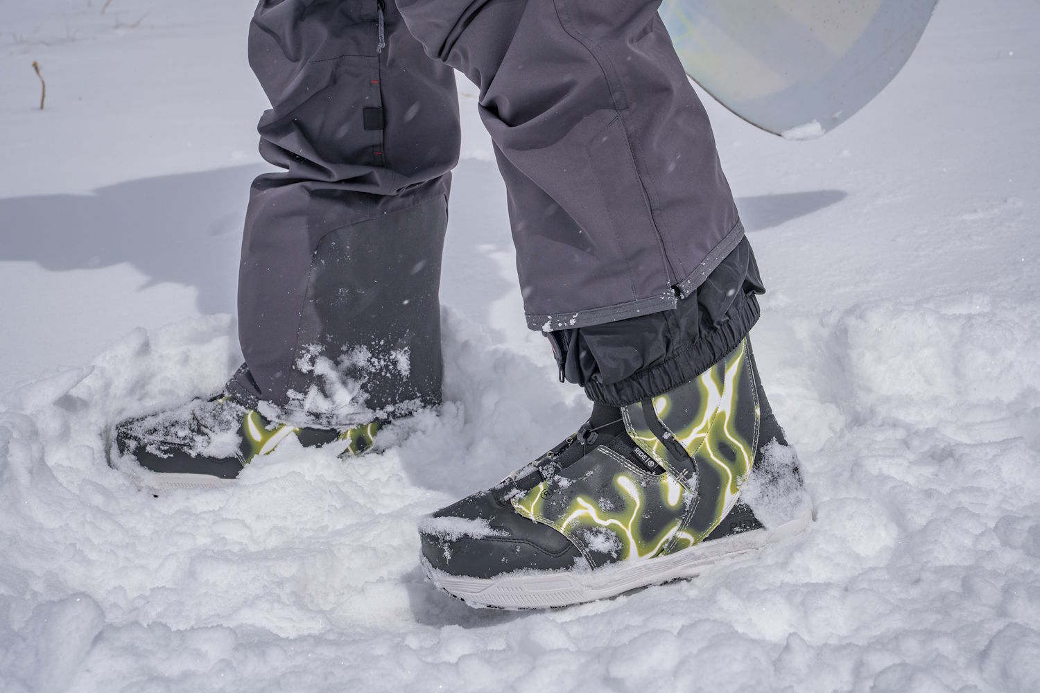 Person wearing snow boots standing in deep snow outdoors.