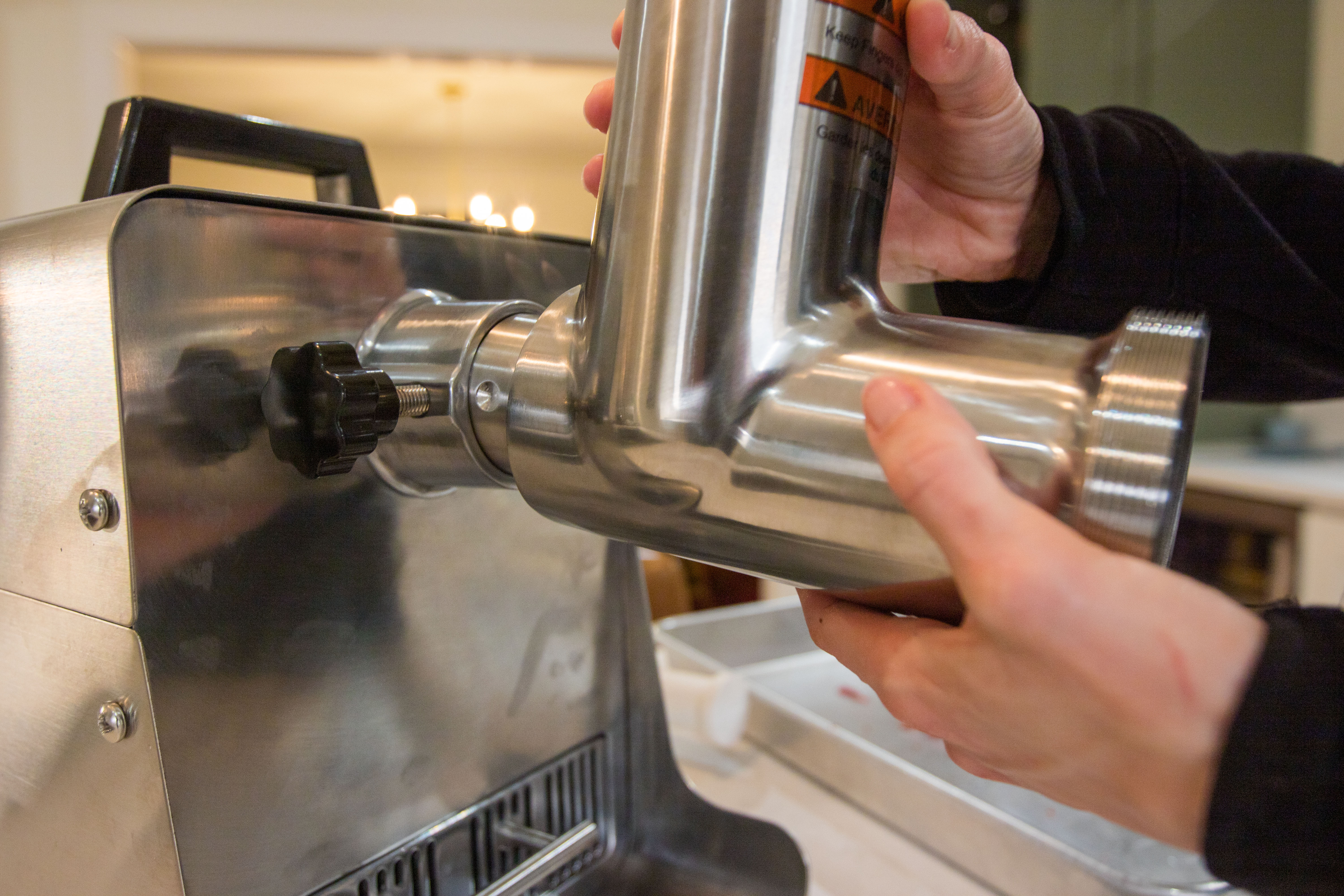 Somone assembling a meat grinder.