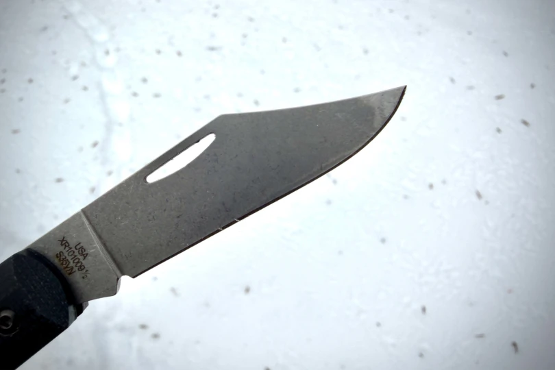 Close view of the Case Crossroads Barlow XR Knife blade tip against a snowy background