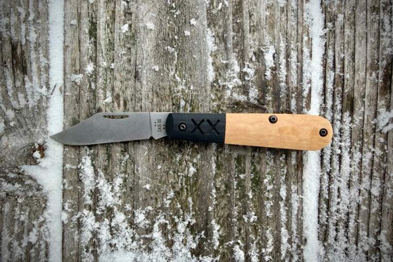 The Case XR Barlow Knife opened and laid flat on a snow-dusted wooden surface