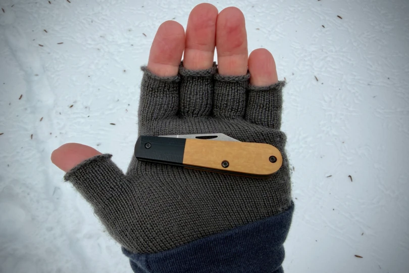 The Case Crossroads knife closed and resting across a gloved hand in the snow