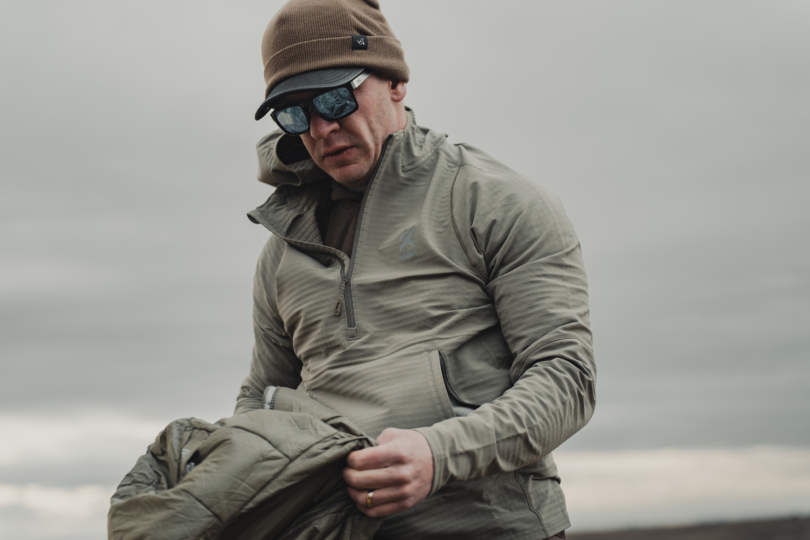 A hunter in the wind wearing the new Kifaru Roam Crosslayer.
