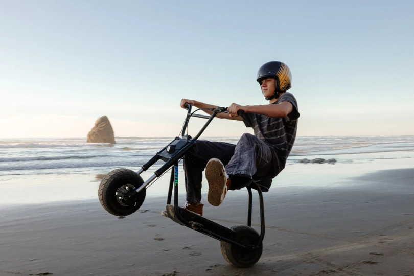 A rider uses the Future Motion Antic eBike on wet sand near the ocean
