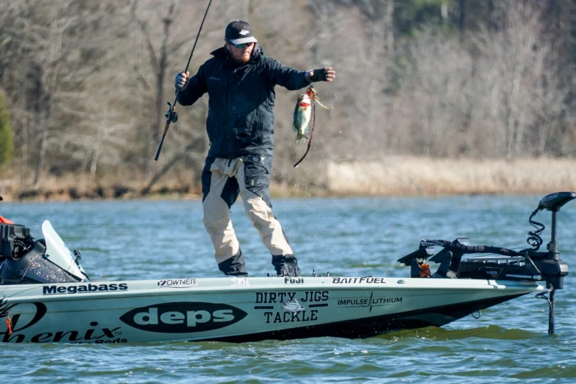 An angler lifting a bass onto his boat during MLF Stage One