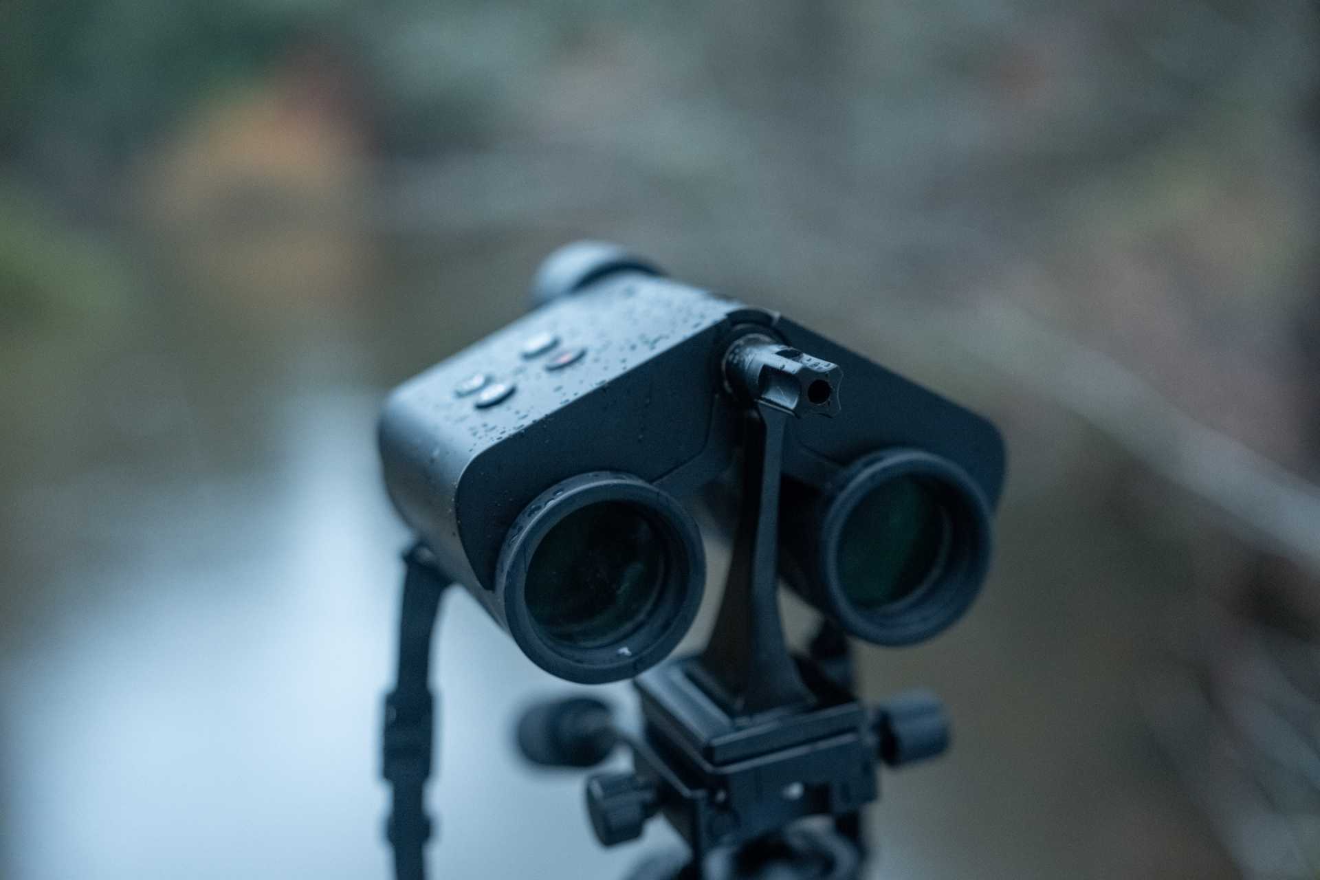 The MatataXplore Solvia ED 8x32 binoculars mounted on a tripod near water, with droplets on the body