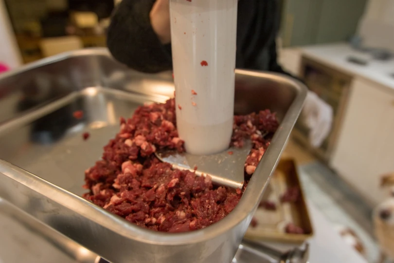 Meat being stuffed into the LEM Big Bite #22 Meat Grinder