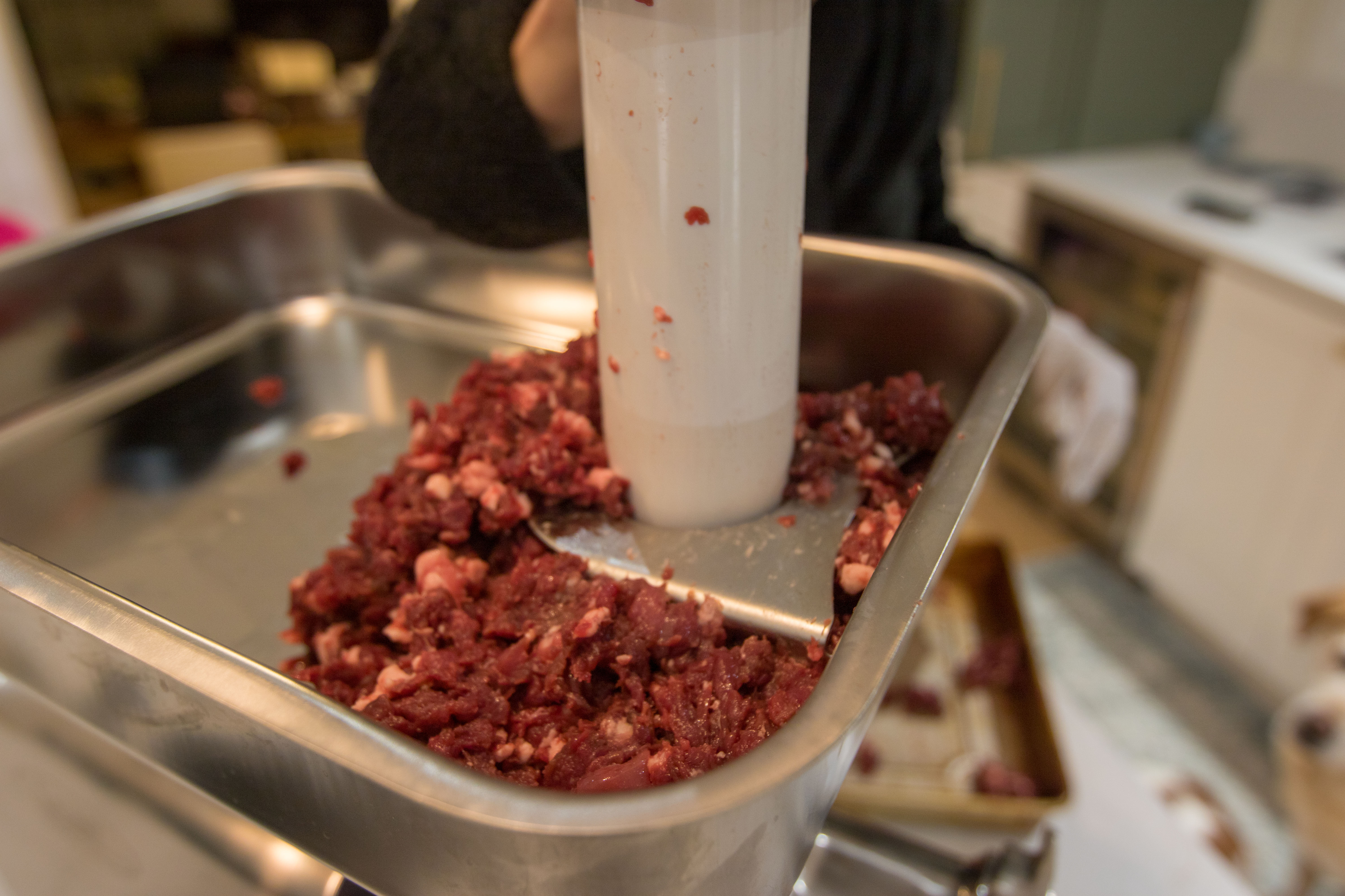 Meat being stuffed into the LEM Big Bite #22 Meat Grinder