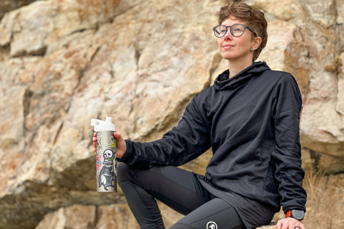 Sambob Octa Teijin Hoody worn by a person sitting on a rock, holding a water bottle