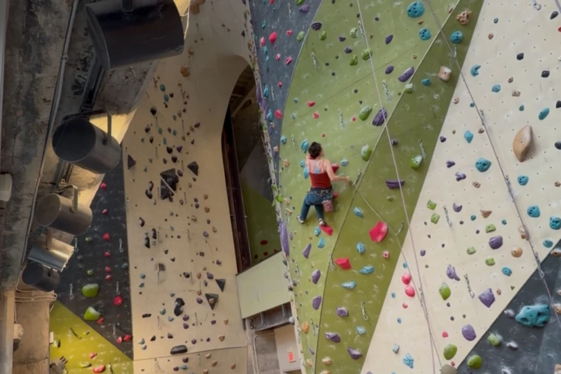 person lead climbing in gym
