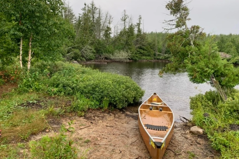 canoe on land by river