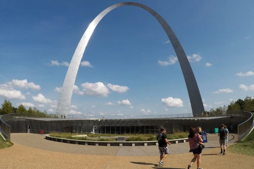 visitors walk by the arch