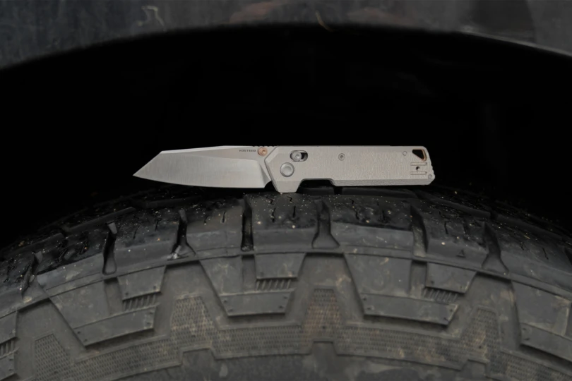 The Vosteed Parallel folding knife shown open in a side profile on a rugged surface