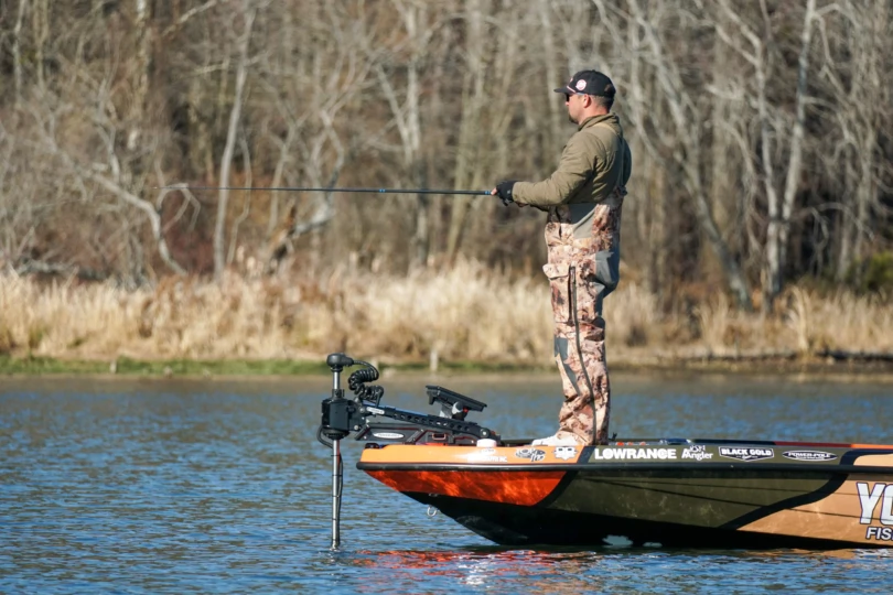 An angler fishing from the front of a bass boat.