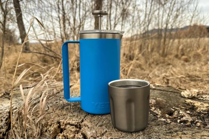 blue yeti french press outdoors next to mug