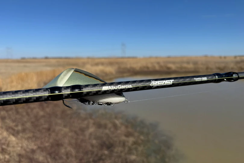 The Abu Garcia Beast combo rod shows carbon fiber blank and branding near a swimbait lure