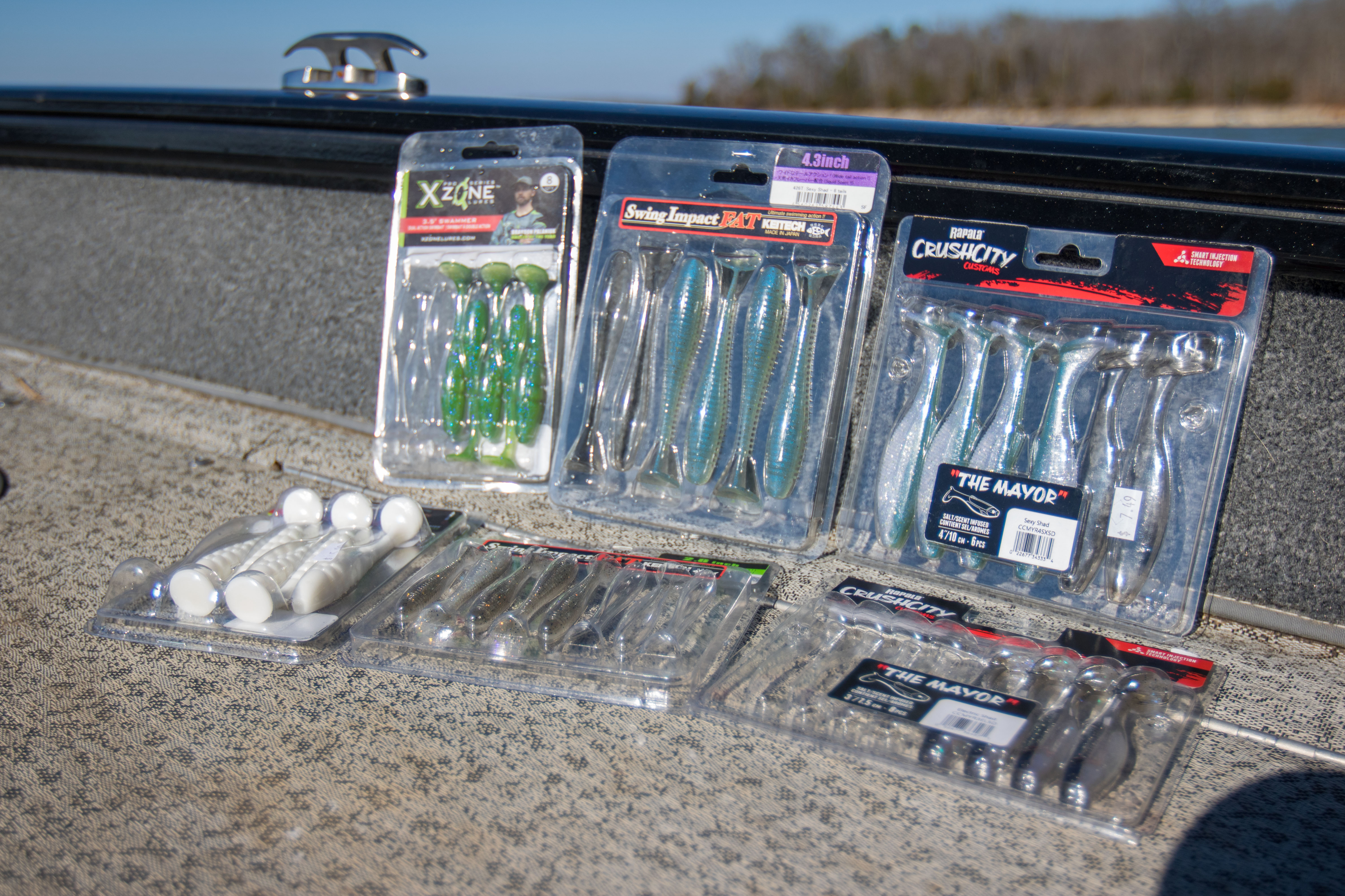 Soft tail swimbaits in packages on a boat deck.