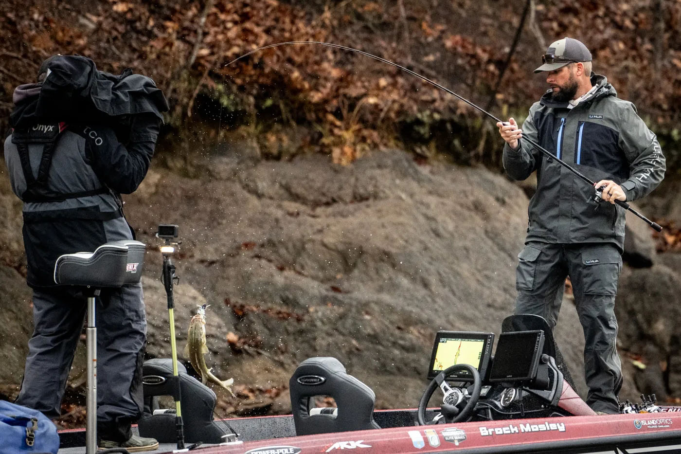 Brock Mosely lifting a fish onto his boat on the Bassmaster Elites at Lake Martin.