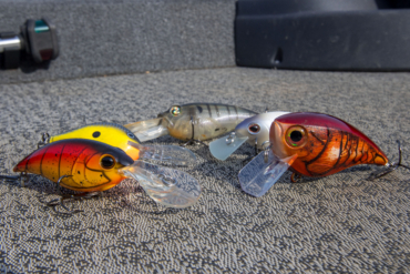 A selection of crankbaits on a boat deck.