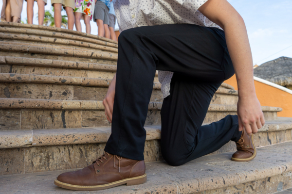 the author kneels down in the unbound merino travel pants in mexico