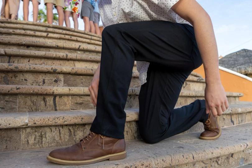 the author kneels down in the unbound merino travel pants in mexico