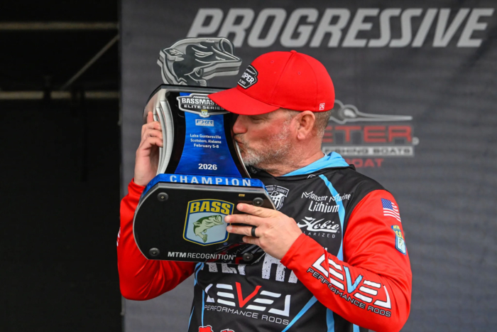 Hank Cherry kissing the trophy from his win at the Bassmaster Elite Series on Lake Guntersville.