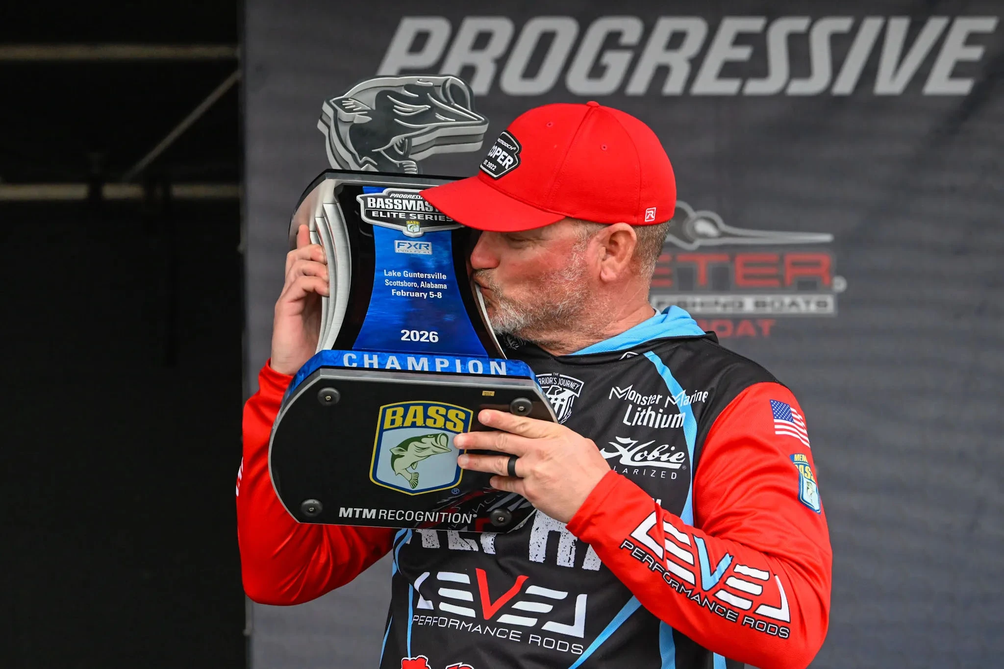 Hank Cherry kissing the trophy from his win at the Bassmaster Elite Series on Lake Guntersville.