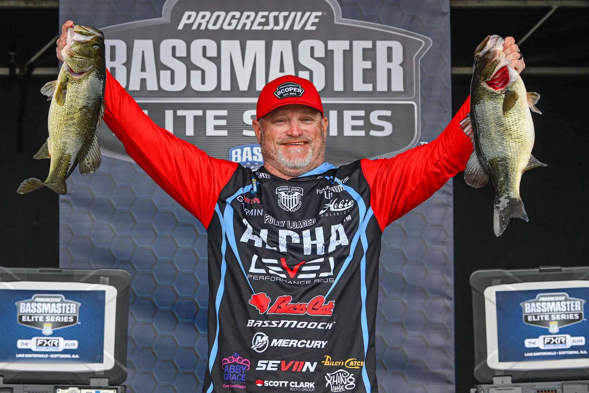 Hank Cherry lifting two bass up at the weigh in.