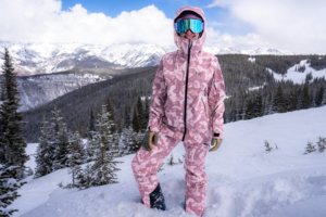 woman standing in snow in ski kit with hood up