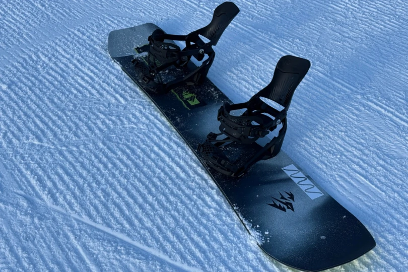 The LT Supermatics are mounted on a snowboard resting on groomed snow